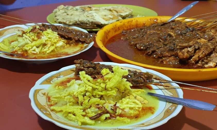 Kupat glabed makanan khas Tegal dengan kuah kuning kental, tempe, sambal merah dan kerupuk mie